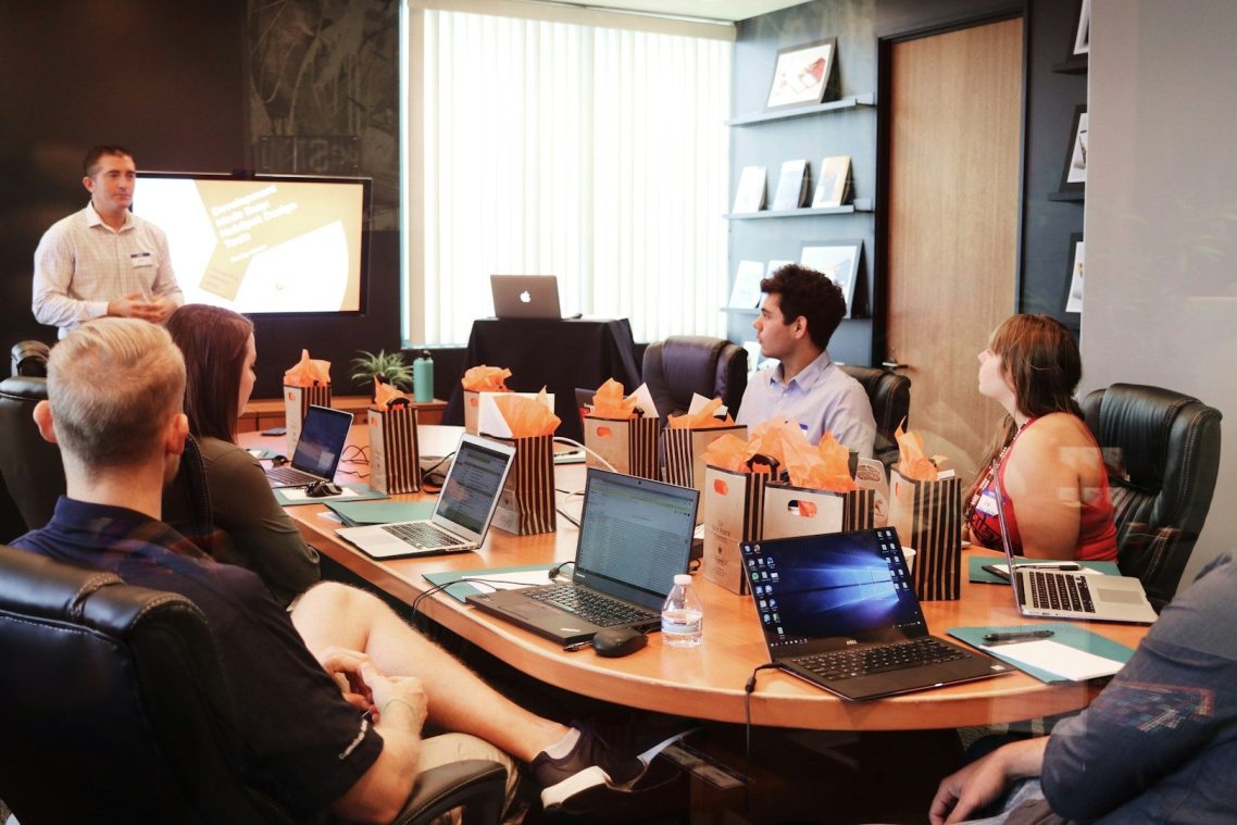 Bold Leadership Path The Method Page A business meeting with participants watching a presentation in a modern conference room.