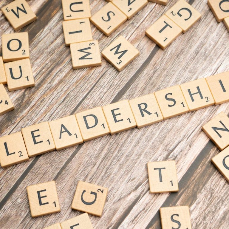 Bold Leadership Path Career Page Scrabble tiles arranged with the word "LEADERSHIP" on a wooden surface.